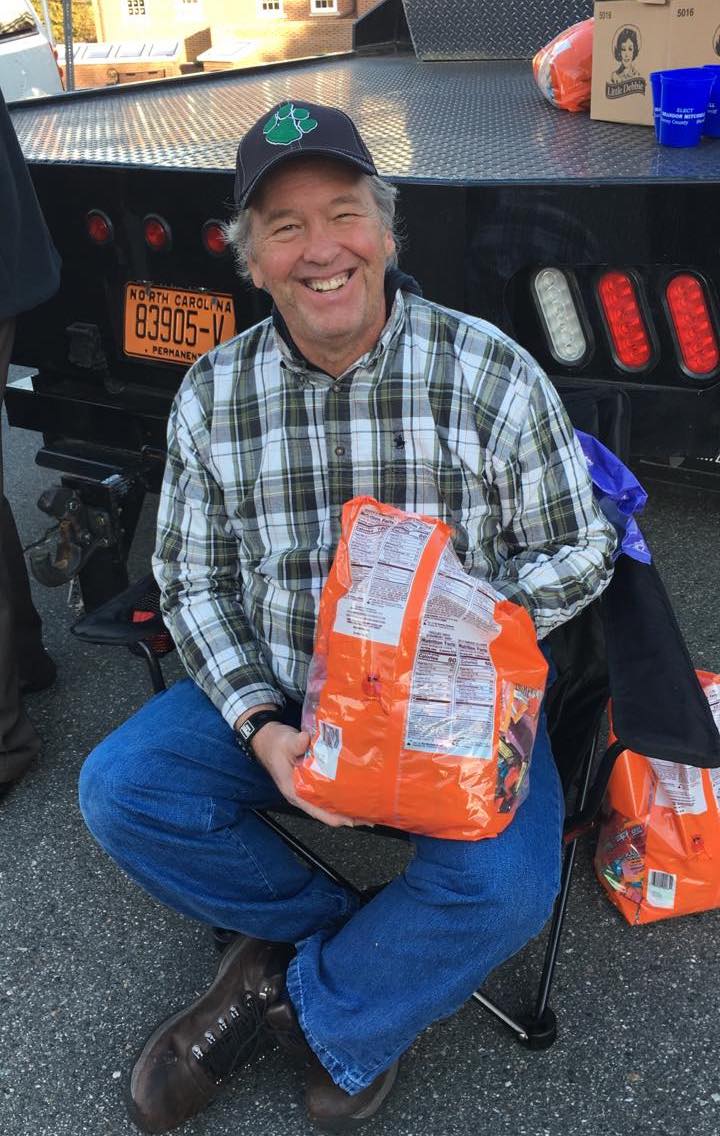 John Stallings appears seated behind a truck, handing out candy.